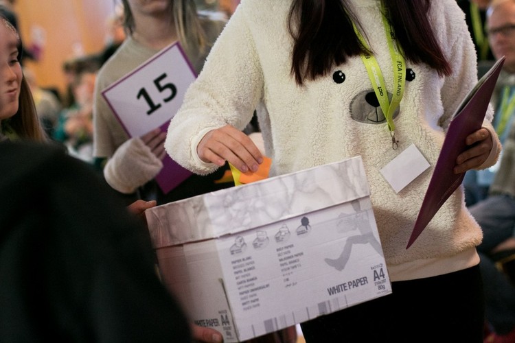 Röstsedel som läggs i en röstlåda av en ung människa.